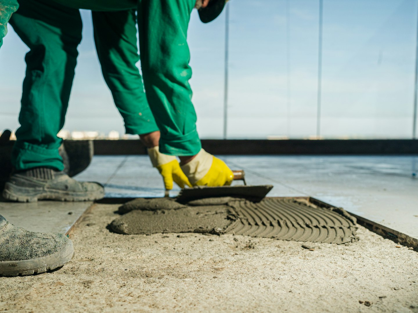 A person in green pants and yellow shoes